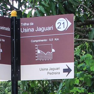 Placa com identificação do trecho de trilha a seguir, com perfil altimétrico e a distância até a próxima junção por aquele trecho. Também indicam os pontos de interesse no trecho. Integram o "Conjunto Direcional".